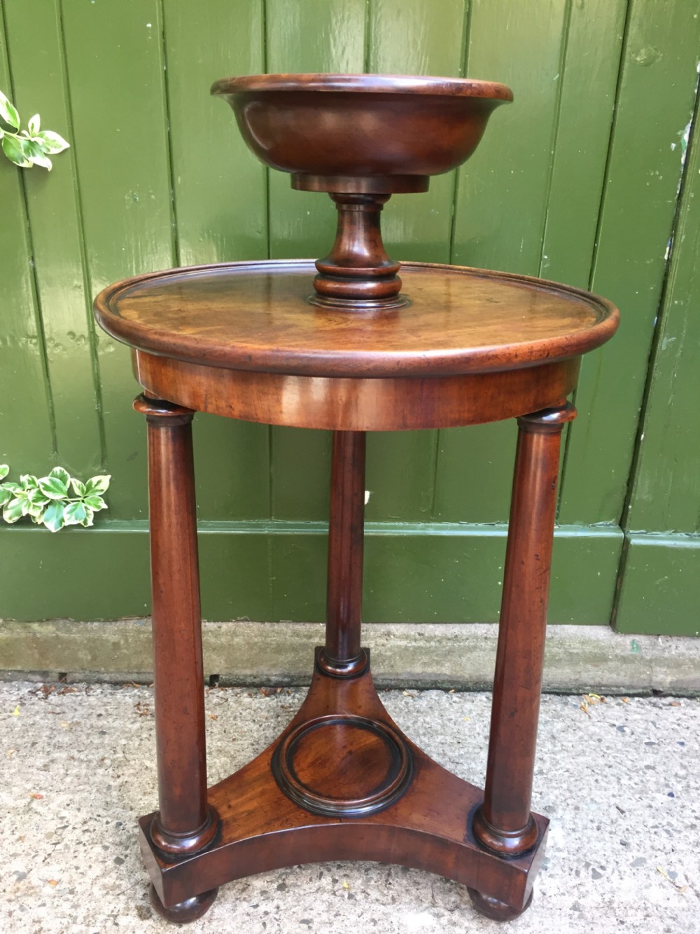 An early 19th-century French circular mahogany vide-poche table featuring a raised turned bowl, three column supports, and a triform base. View III