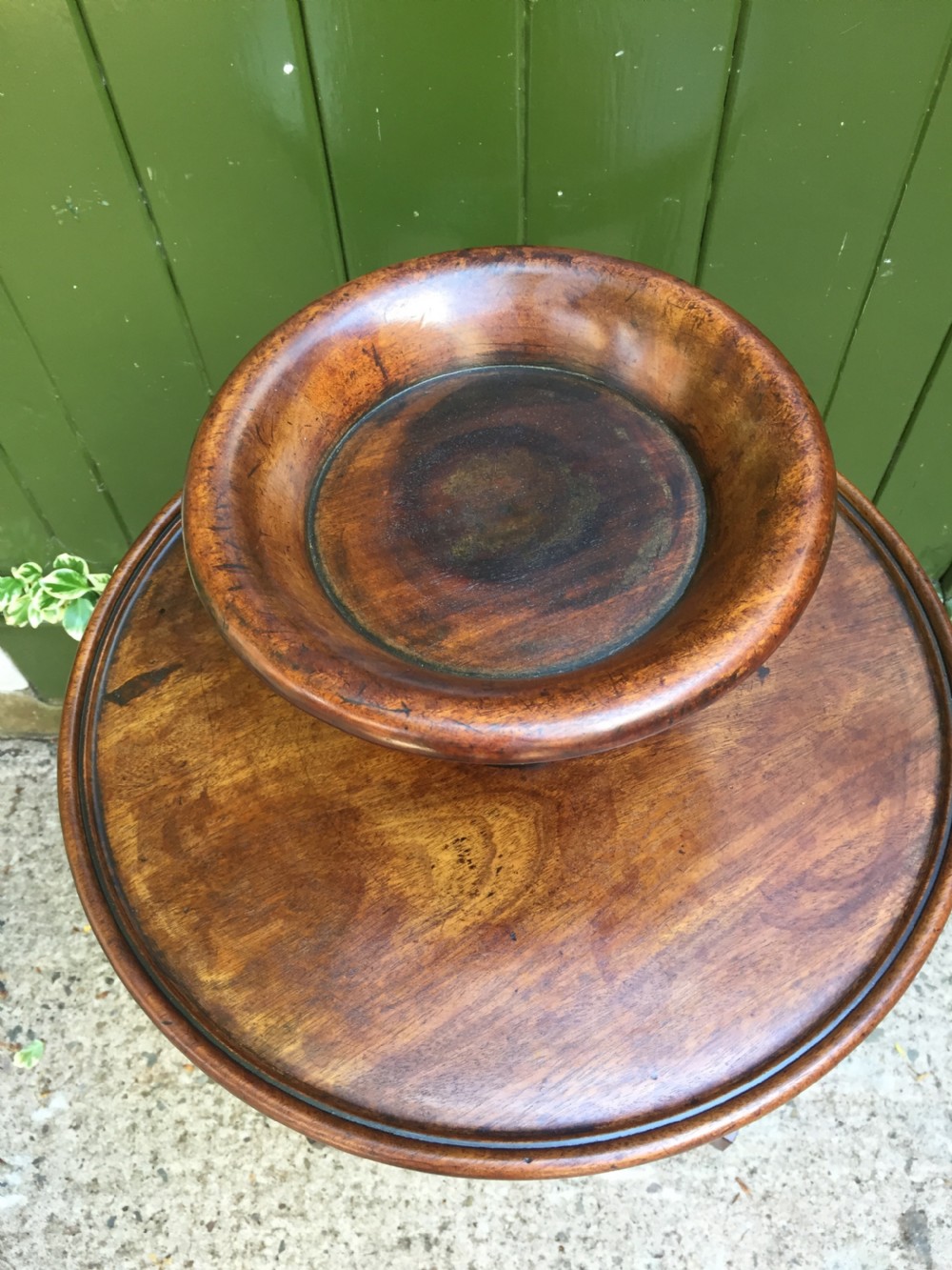 An early 19th-century French circular mahogany vide-poche table featuring a raised turned bowl, three column supports, and a triform base. View VI