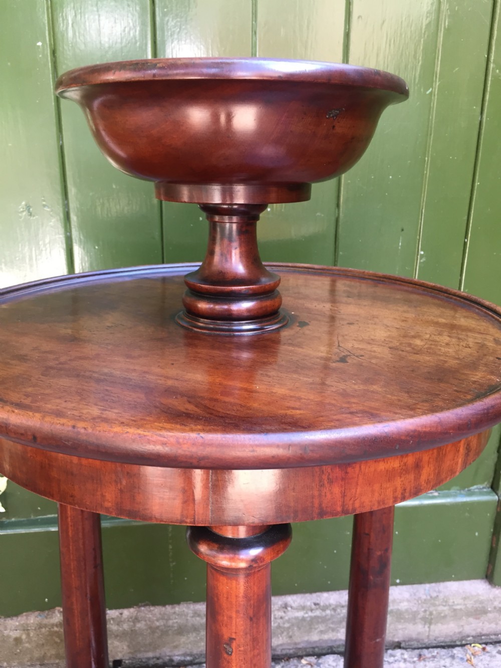 An early 19th-century French circular mahogany vide-poche table featuring a raised turned bowl, three column supports, and a triform base. View IX