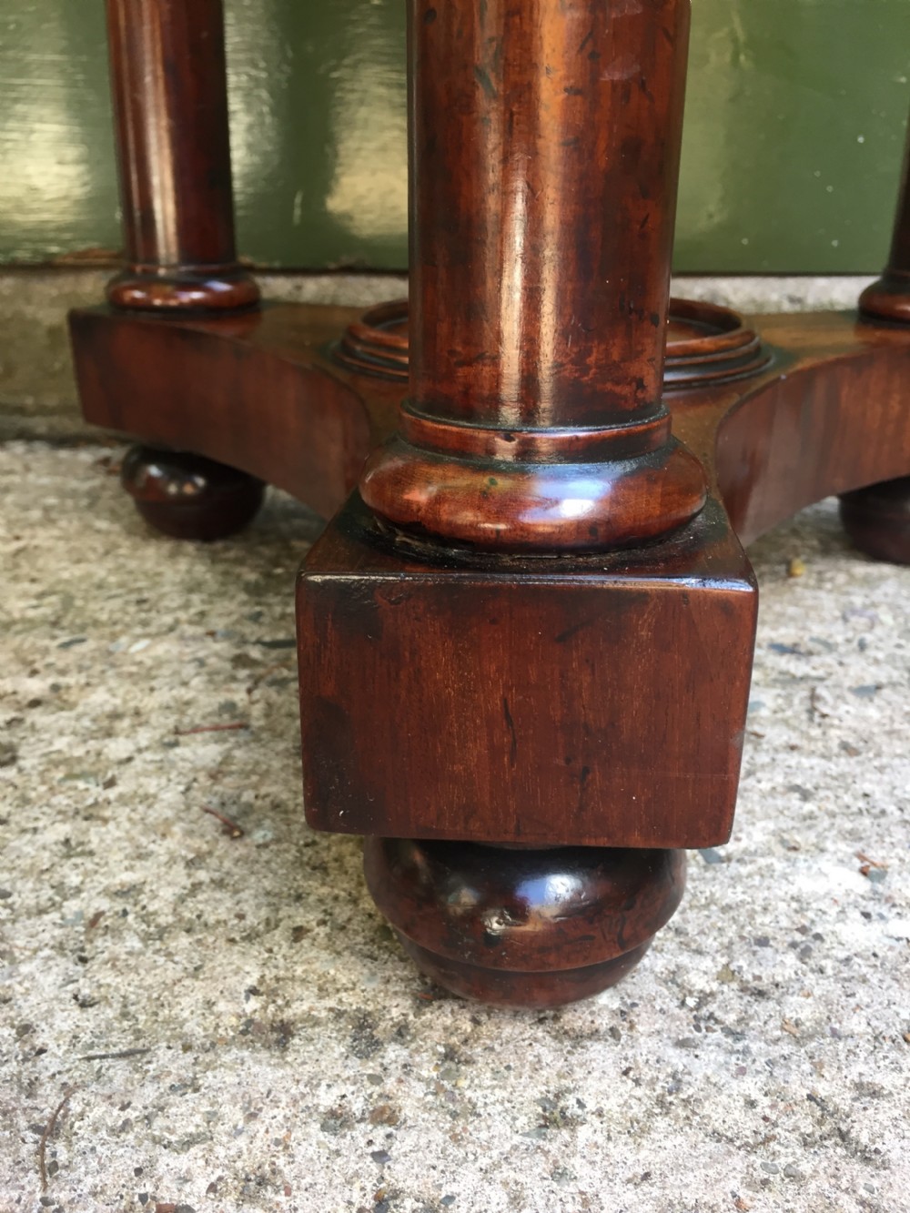 An early 19th-century French circular mahogany vide-poche table featuring a raised turned bowl, three column supports, and a triform base. View XI
