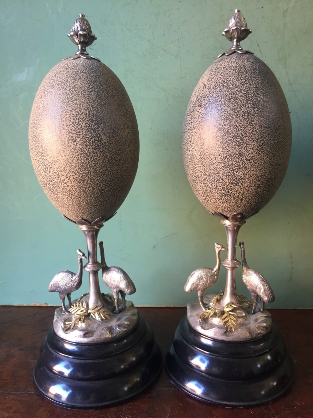 Of Australian interest: Pair of late C19th silver-plated mounted Emu eggs on ebonised socle bases.