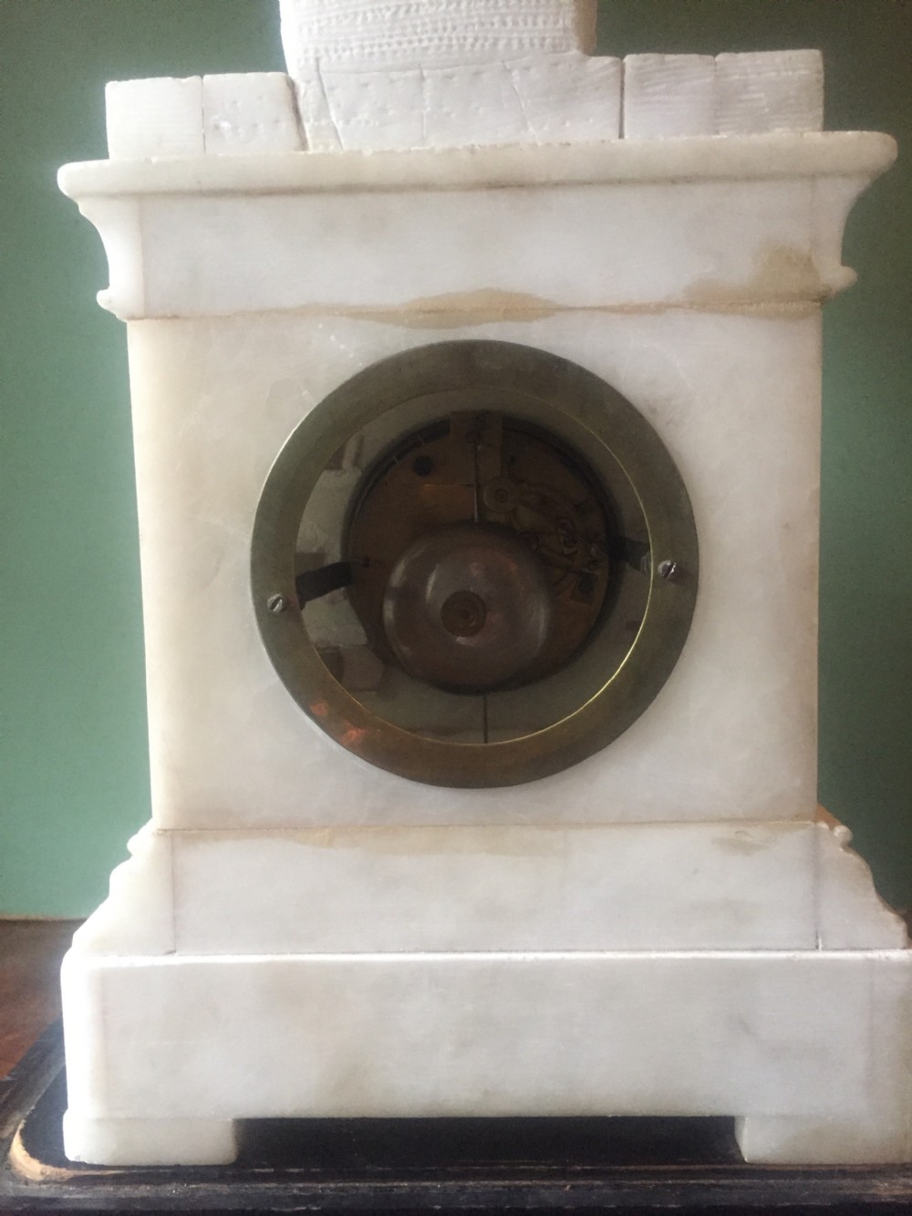 A nineteenth-century carved white alabaster mantel clock featuring a seated classical figure on a pedestal base enclosed under a tall glass dome. View XVI