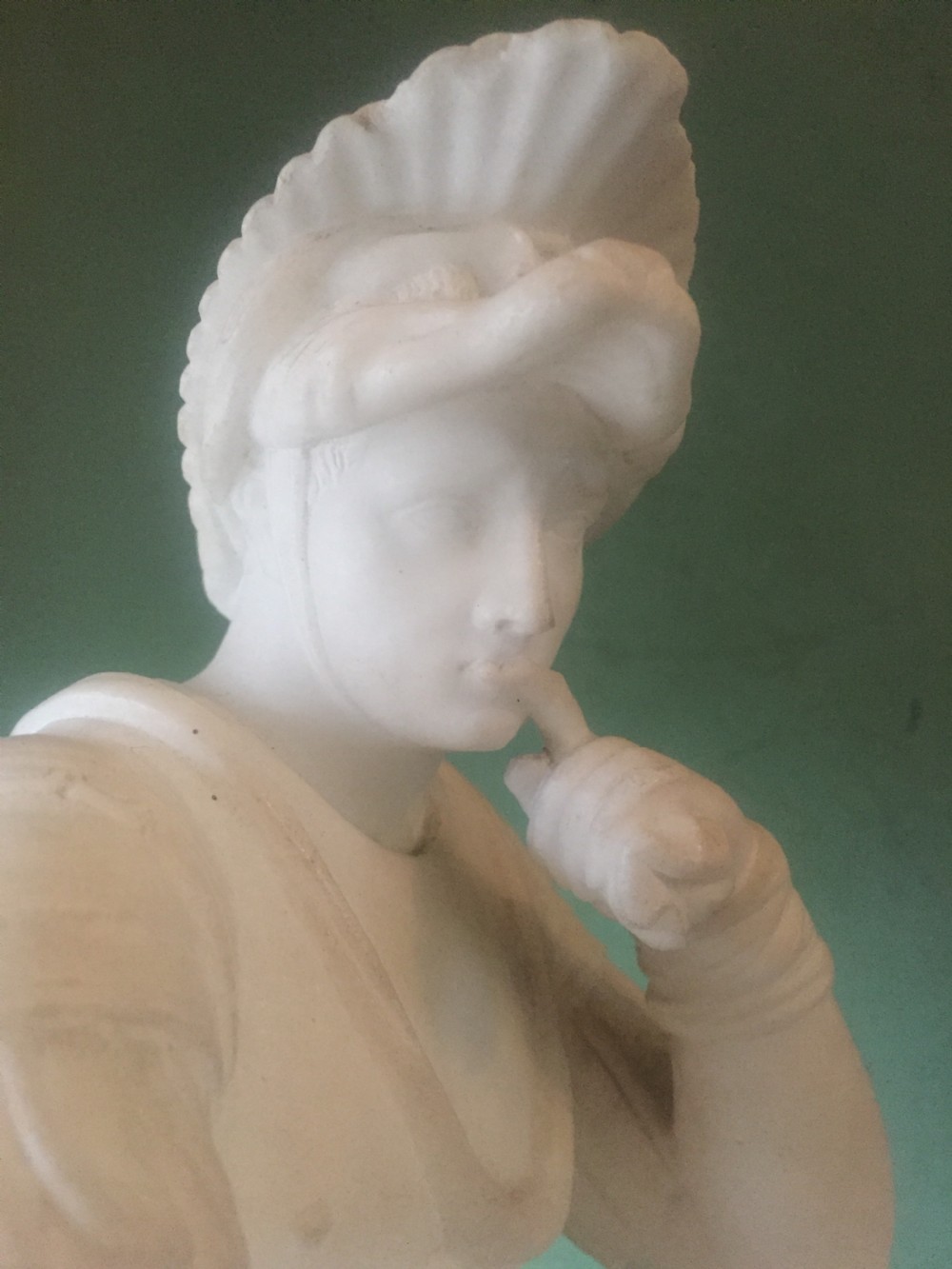 A nineteenth-century carved white alabaster mantel clock featuring a seated classical figure on a pedestal base enclosed under a tall glass dome. View XXII