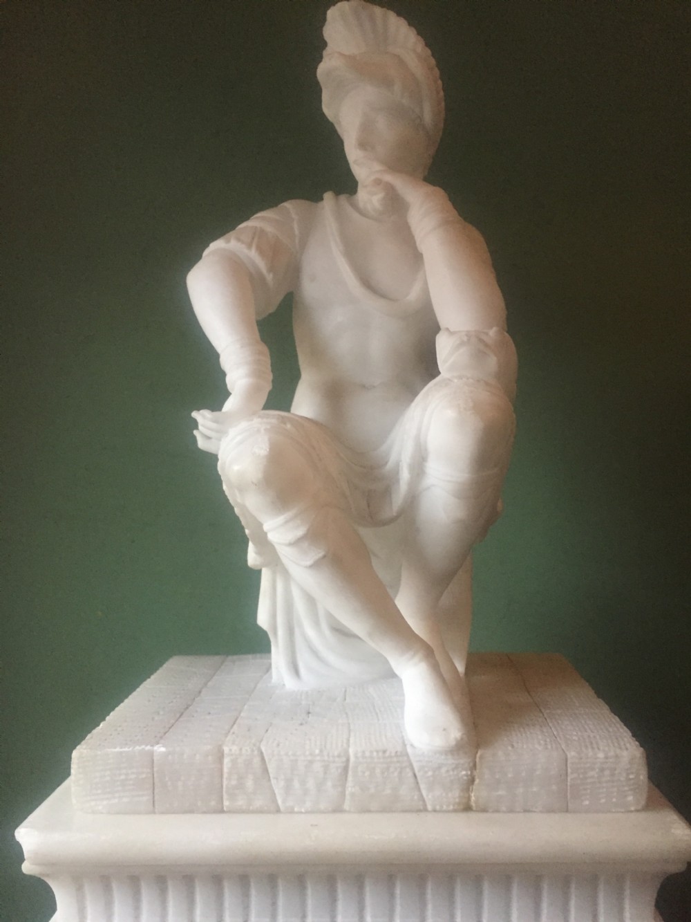 A nineteenth-century carved white alabaster mantel clock featuring a seated classical figure on a pedestal base enclosed under a tall glass dome. View XXV