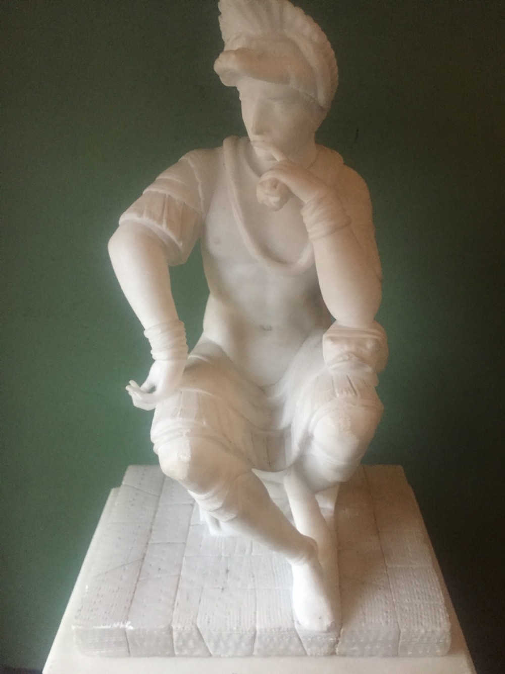 A nineteenth-century carved white alabaster mantel clock featuring a seated classical figure on a pedestal base enclosed under a tall glass dome. View XXVI