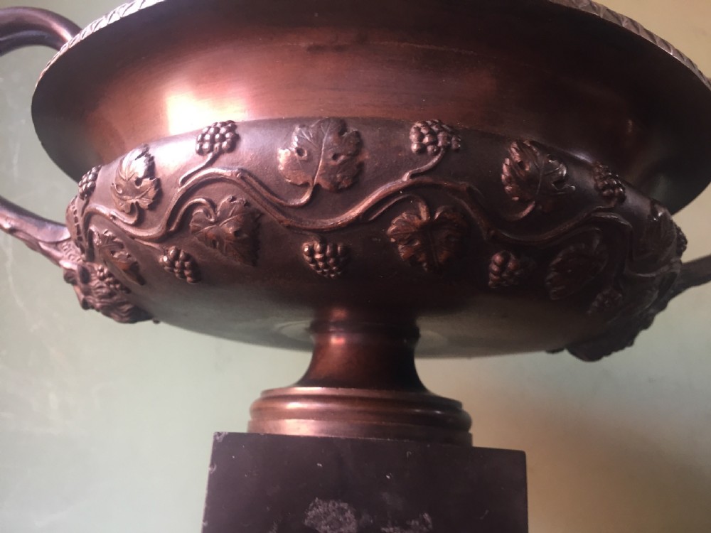 An early nineteenth-century Italian bronze twin-handled tazza featuring relief-carved vine leaves and grapes mounted on a square black base. View VI