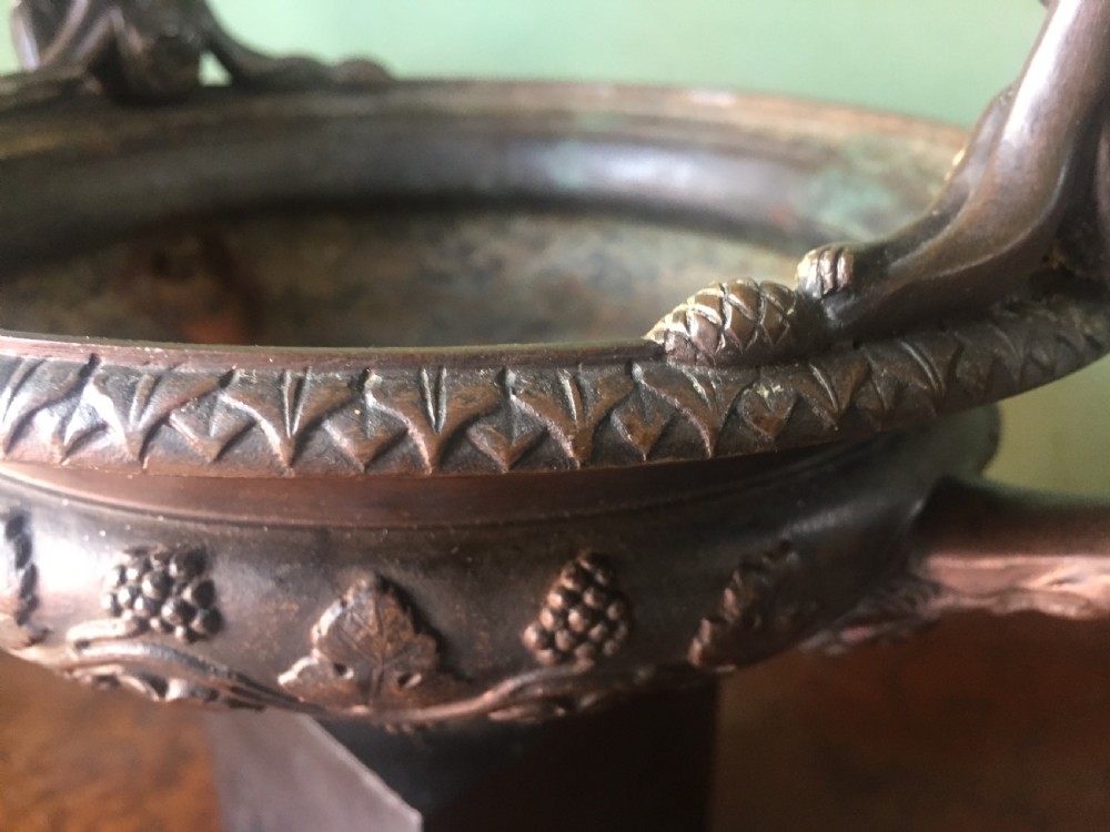 An early nineteenth-century Italian bronze twin-handled tazza featuring relief-carved vine leaves and grapes mounted on a square black base. View IX