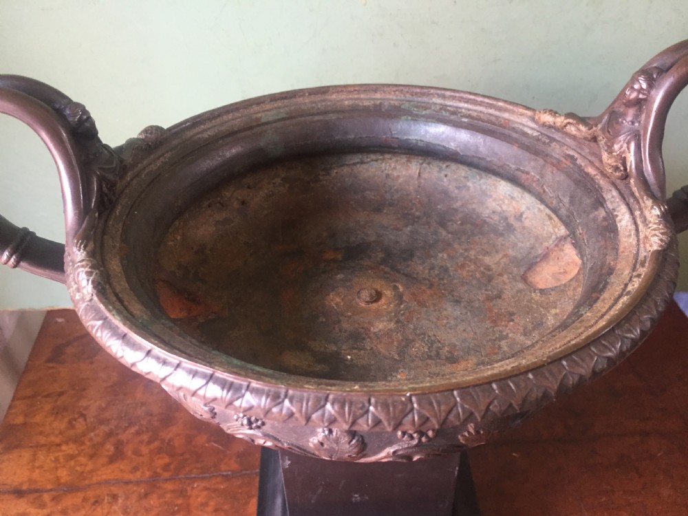 An early nineteenth-century Italian bronze twin-handled tazza featuring relief-carved vine leaves and grapes mounted on a square black base. View X