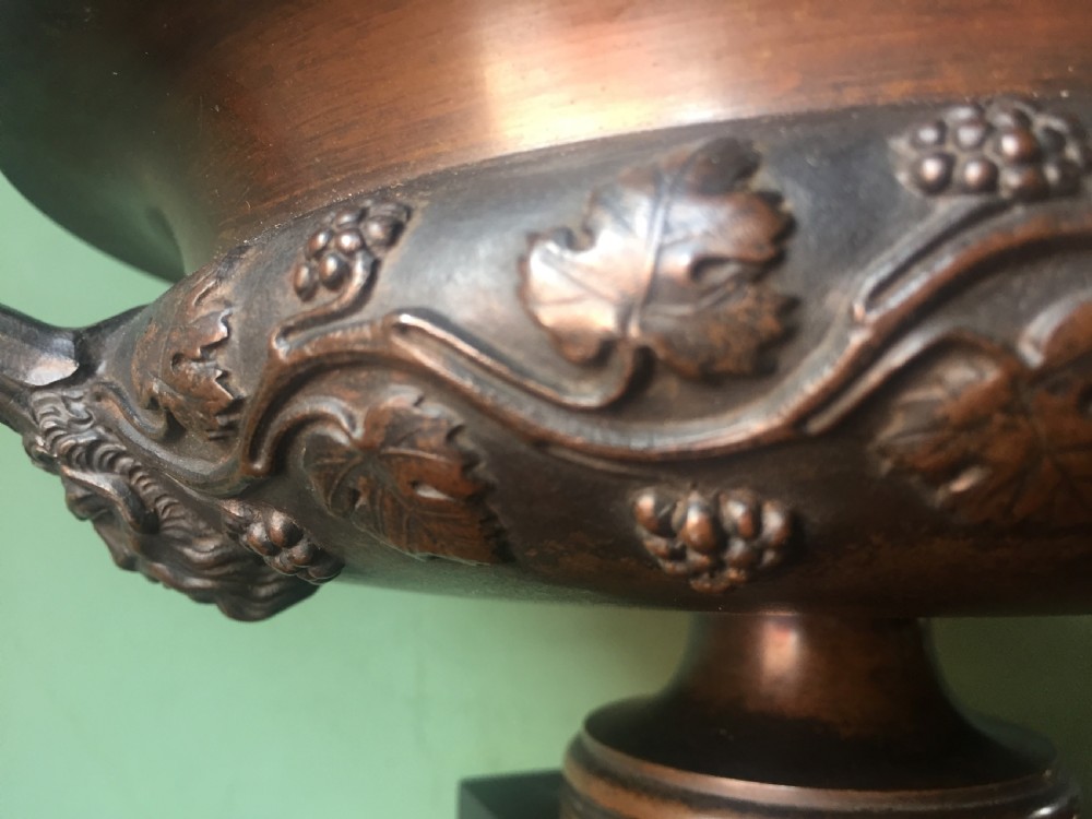 An early nineteenth-century Italian bronze twin-handled tazza featuring relief-carved vine leaves and grapes mounted on a square black base. View XII