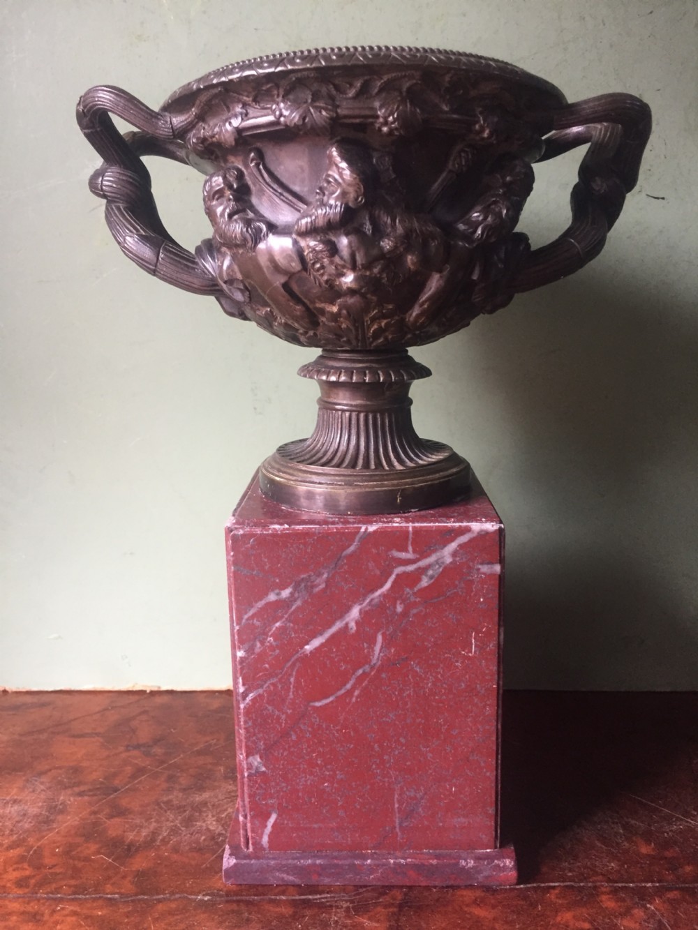 A nineteenth-century dark bronze reduction of the Warwick Vase with Bacchanalian masks and vine handles, mounted on a red marble square base. View II