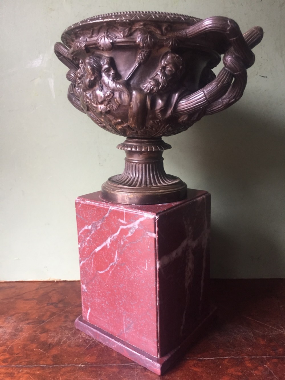 A nineteenth-century dark bronze reduction of the Warwick Vase with Bacchanalian masks and vine handles, mounted on a red marble square base. View III
