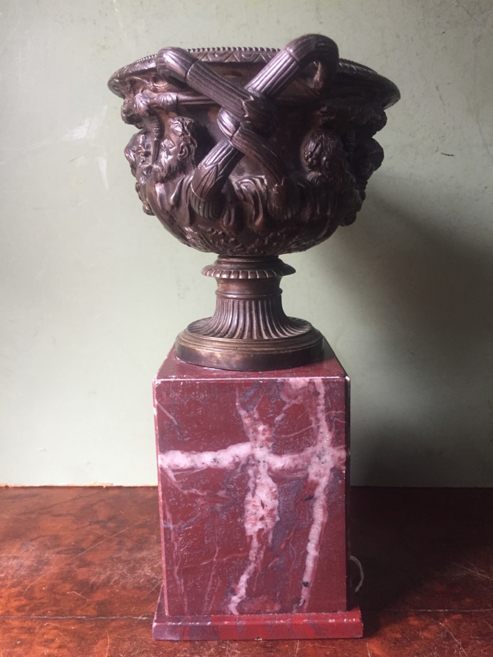 A nineteenth-century dark bronze reduction of the Warwick Vase with Bacchanalian masks and vine handles, mounted on a red marble square base. View V