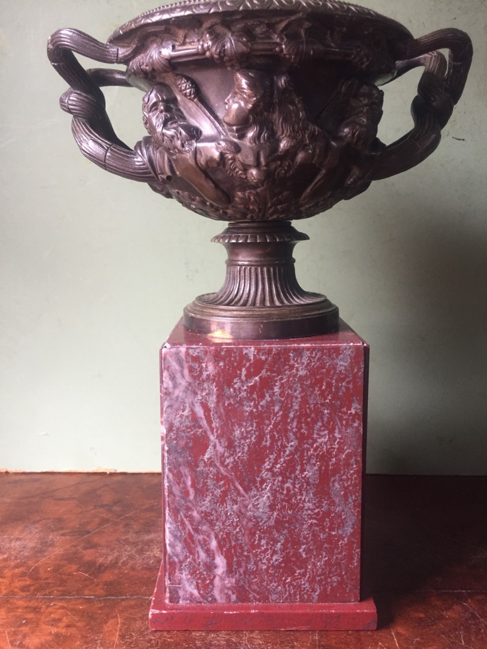A nineteenth-century dark bronze reduction of the Warwick Vase with Bacchanalian masks and vine handles, mounted on a red marble square base. View VI