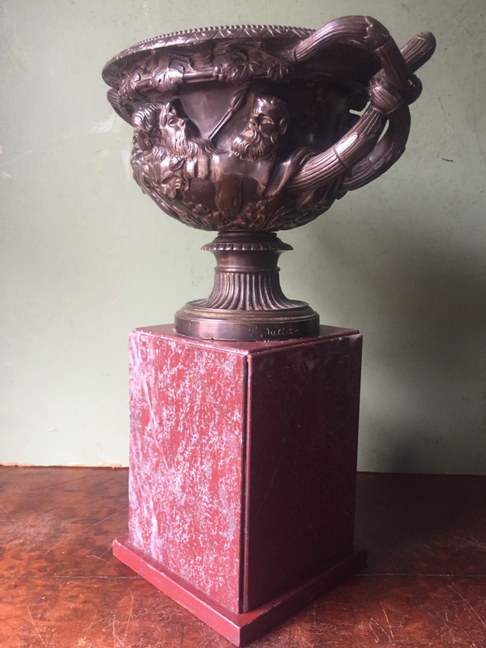 A nineteenth-century dark bronze reduction of the Warwick Vase with Bacchanalian masks and vine handles, mounted on a red marble square base. View VII