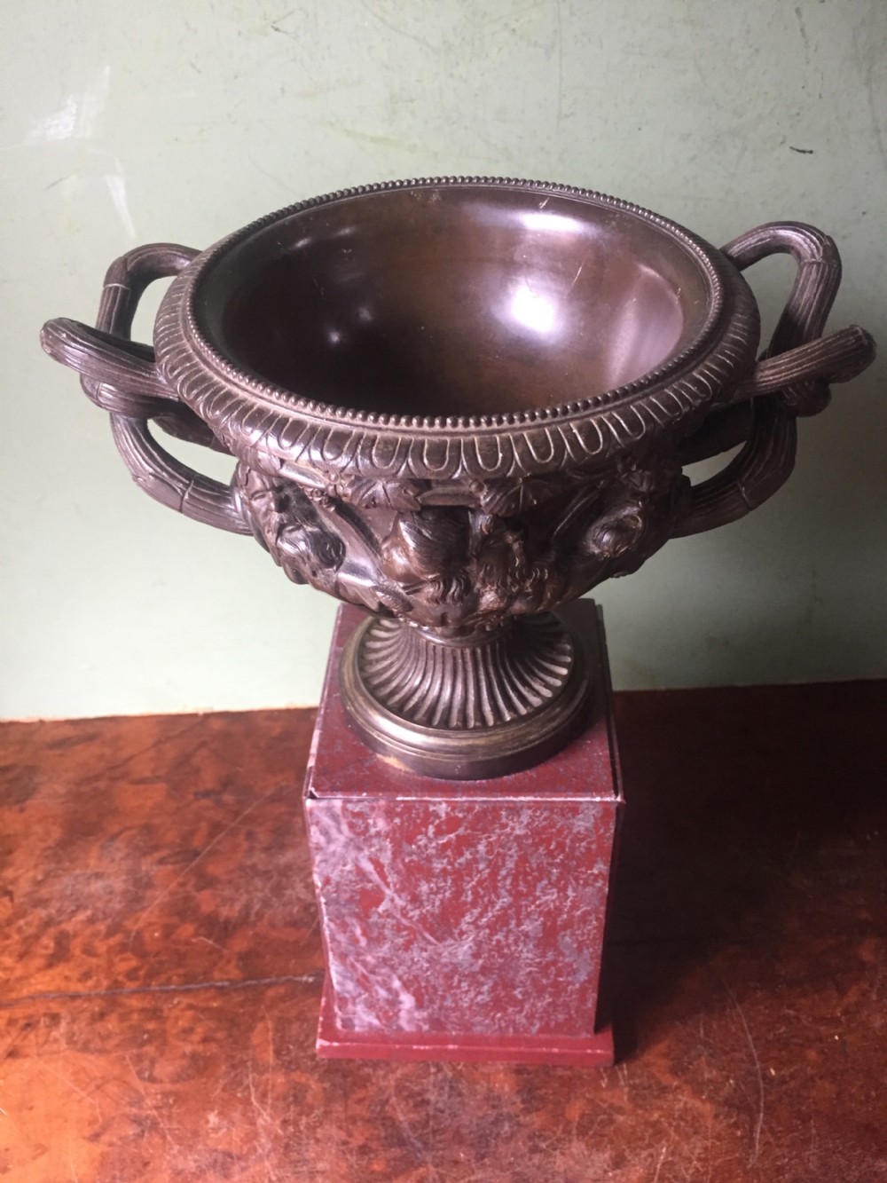 A nineteenth-century dark bronze reduction of the Warwick Vase with Bacchanalian masks and vine handles, mounted on a red marble square base. View XI