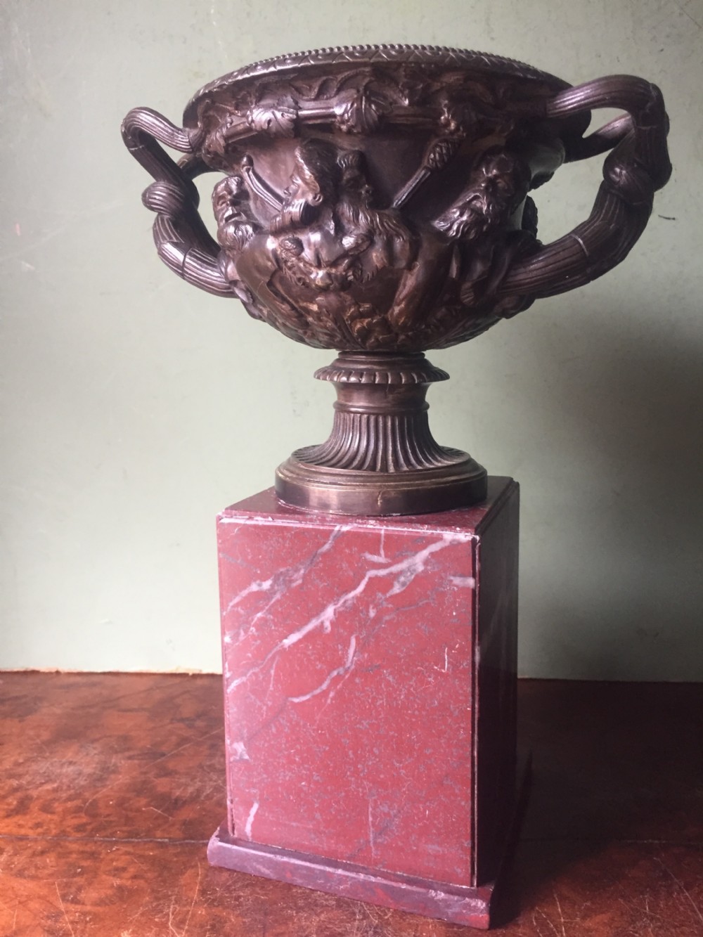 A nineteenth-century dark bronze reduction of the Warwick Vase with Bacchanalian masks and vine handles, mounted on a red marble square base. View XII