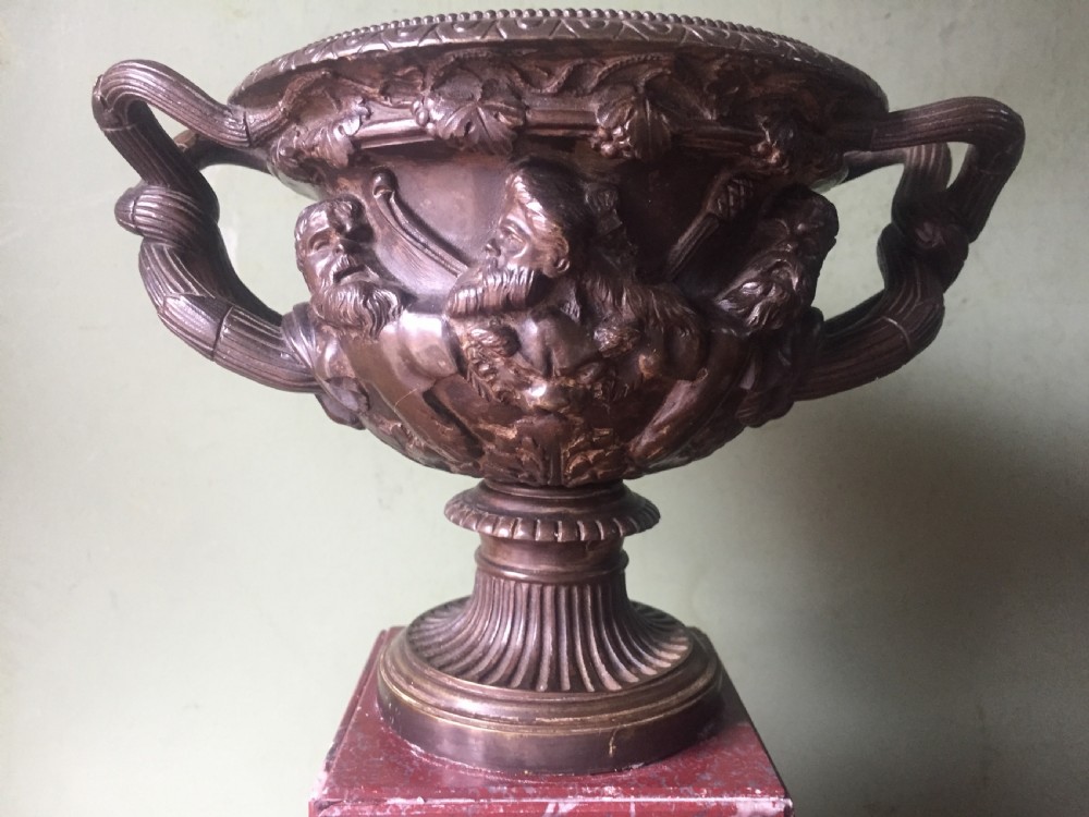 A nineteenth-century dark bronze reduction of the Warwick Vase with Bacchanalian masks and vine handles, mounted on a red marble square base. View XIII