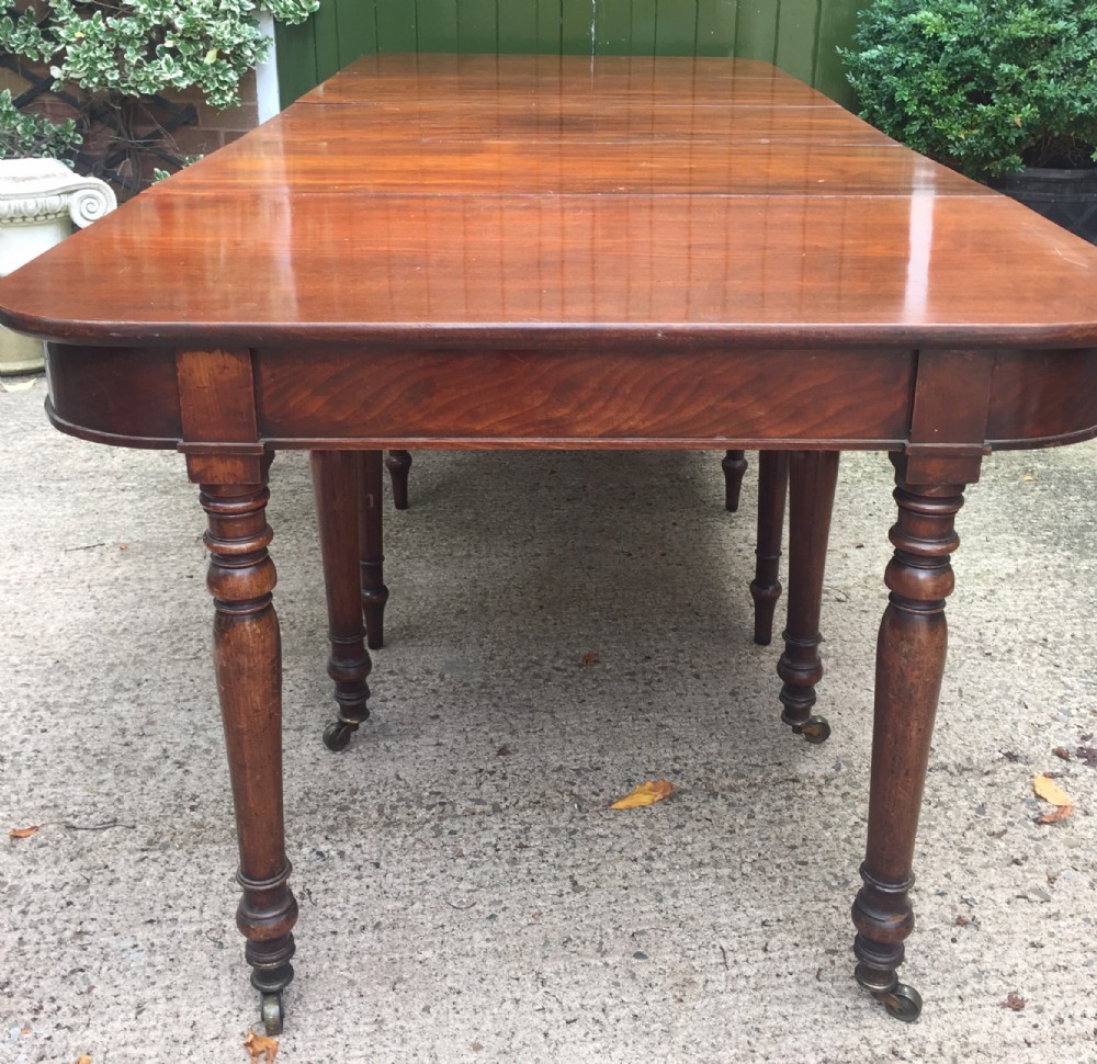 A Regency mahogany extending dining table with turned legs and brass castors.