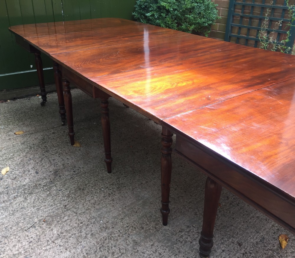 A Regency mahogany extending dining table with turned legs and brass castors. View III