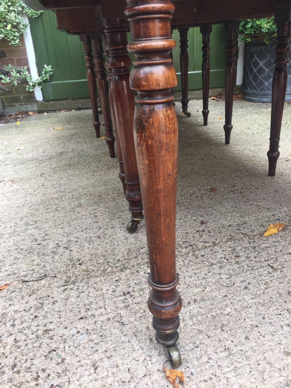 A Regency mahogany extending dining table with turned legs and brass castors. View V