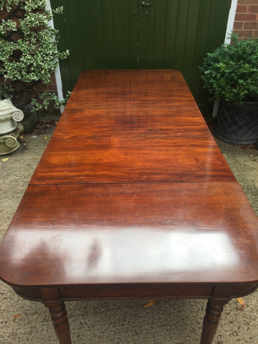 A Regency mahogany extending dining table with turned legs and brass castors. View XI