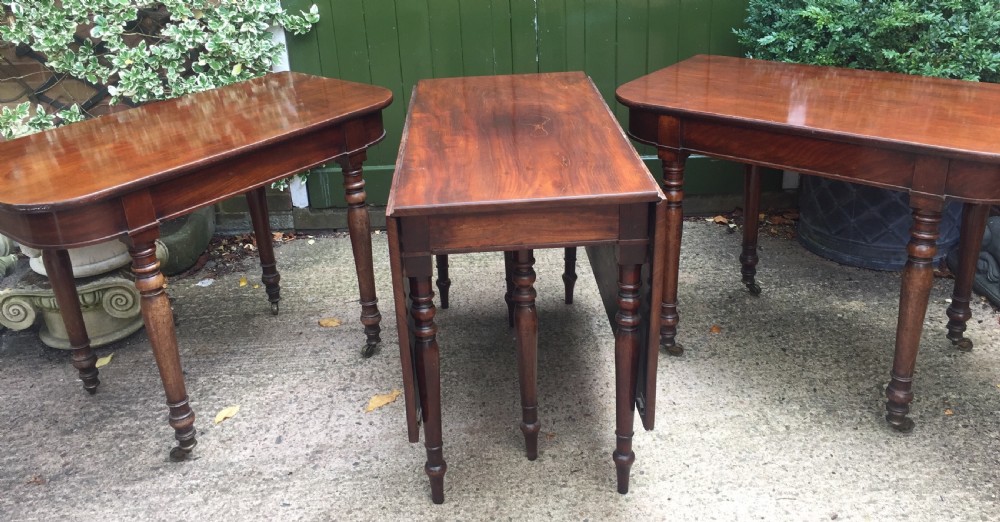 A Regency mahogany extending dining table with turned legs and brass castors. View XII