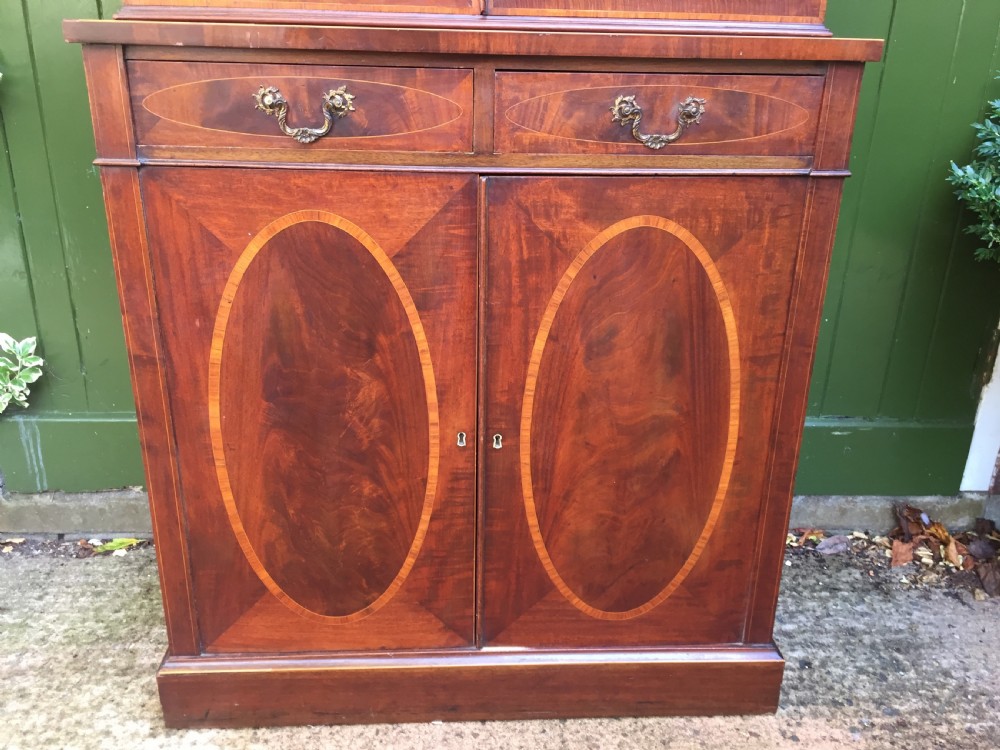 A late Victorian mahogany glazed cabinet featuring upper astragal doors with gothic tracery above two drawers and oval inlaid cupboard doors. View V