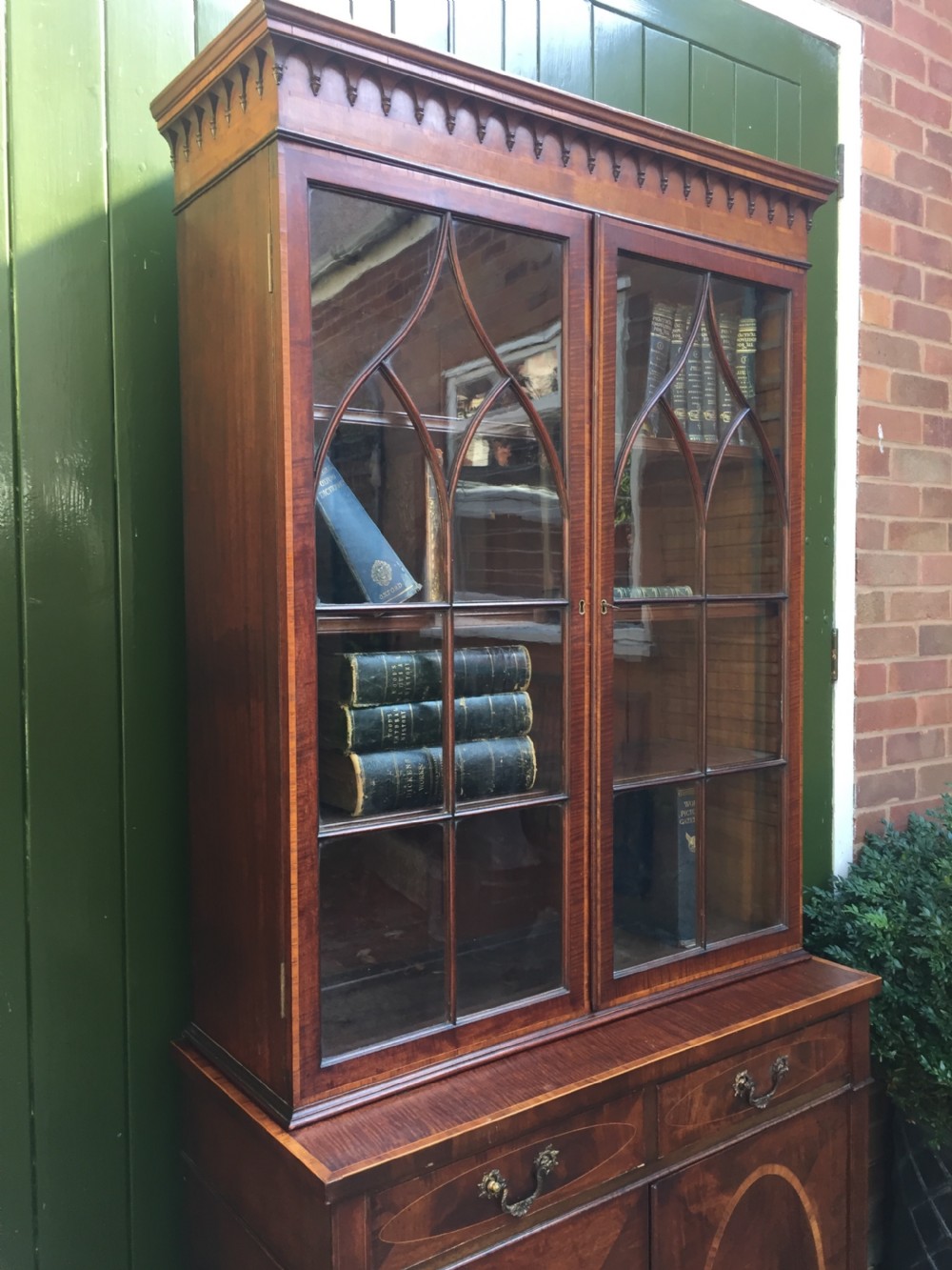 A late Victorian mahogany glazed cabinet featuring upper astragal doors with gothic tracery above two drawers and oval inlaid cupboard doors. View VII