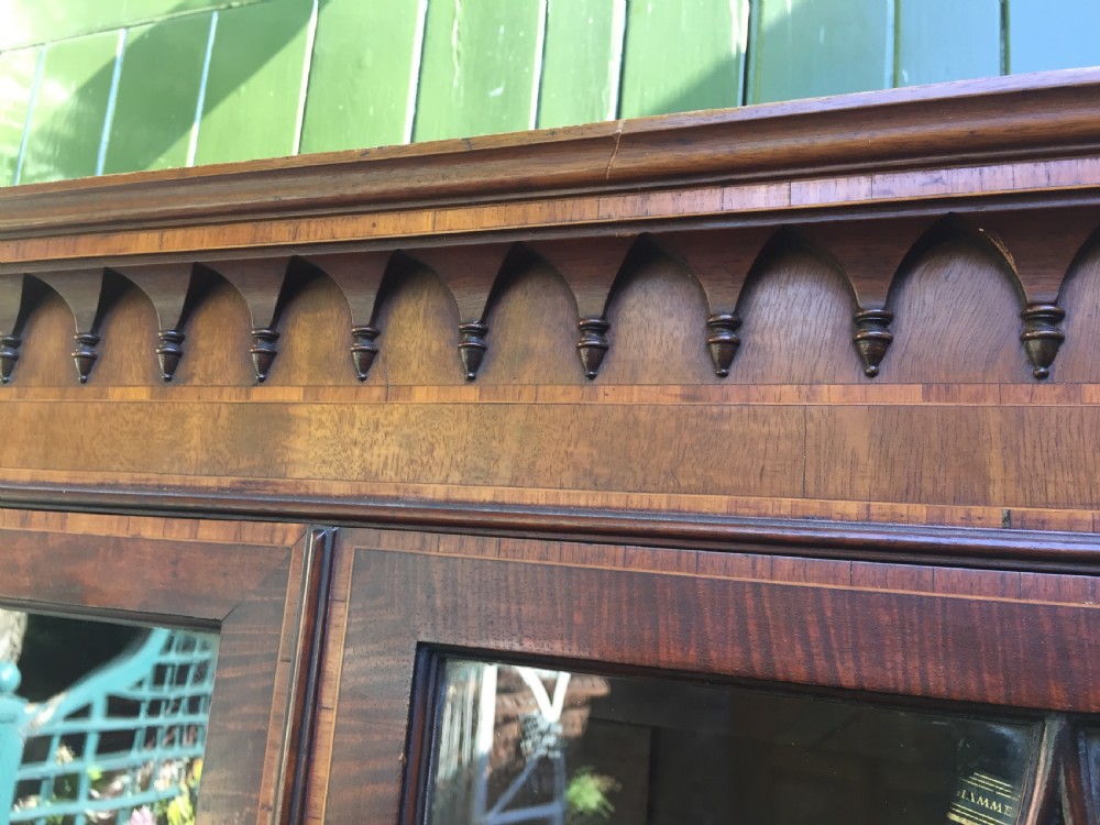 A late Victorian mahogany glazed cabinet featuring upper astragal doors with gothic tracery above two drawers and oval inlaid cupboard doors. View X