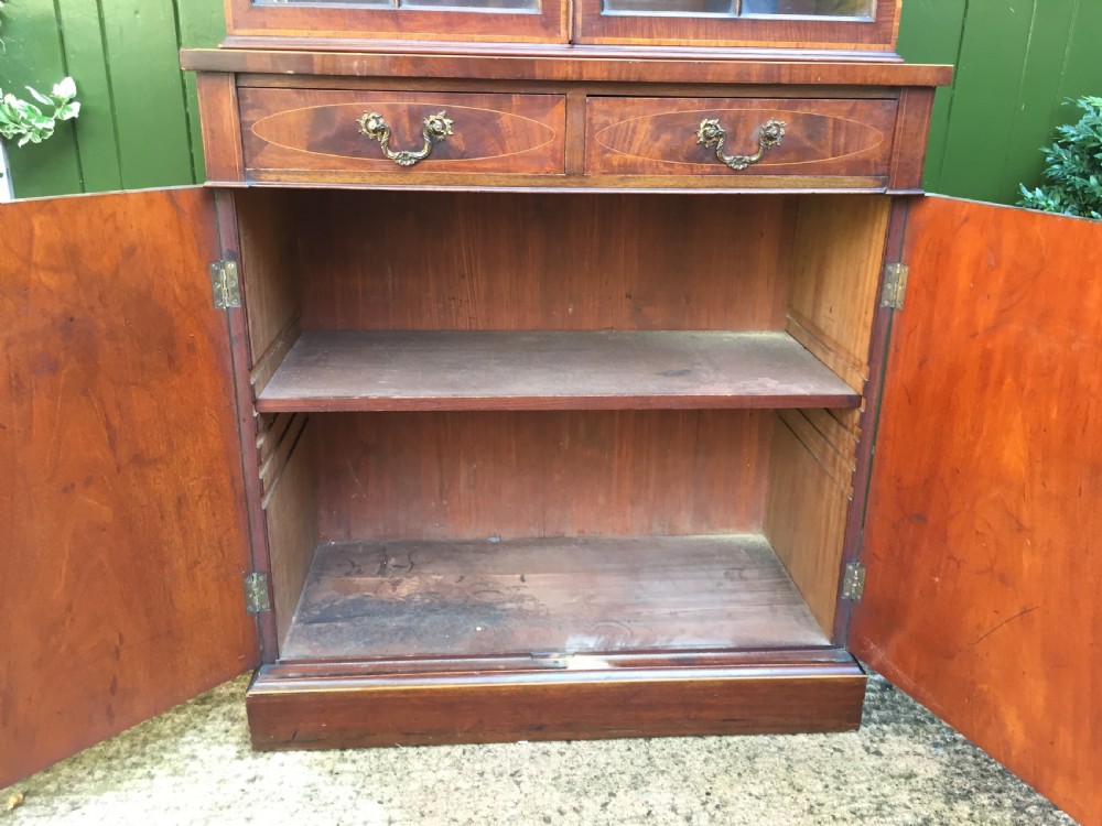 A late Victorian mahogany glazed cabinet featuring upper astragal doors with gothic tracery above two drawers and oval inlaid cupboard doors. View XII