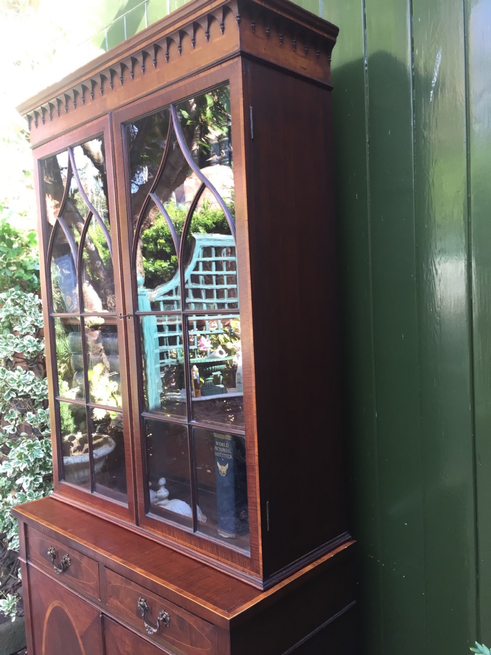 A late Victorian mahogany glazed cabinet featuring upper astragal doors with gothic tracery above two drawers and oval inlaid cupboard doors. View XVI