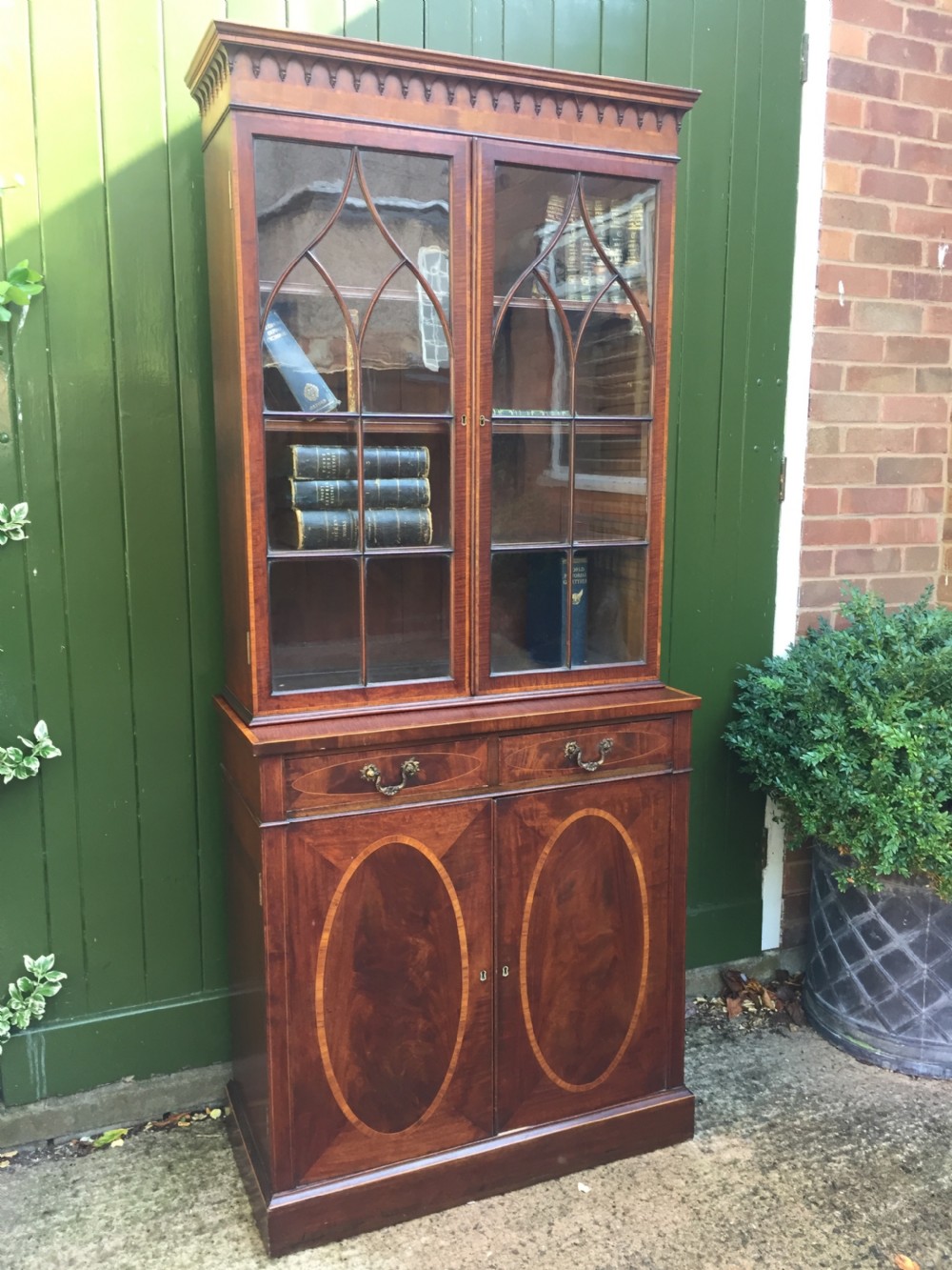 A late Victorian mahogany glazed cabinet featuring upper astragal doors with gothic tracery above two drawers and oval inlaid cupboard doors. View XIX