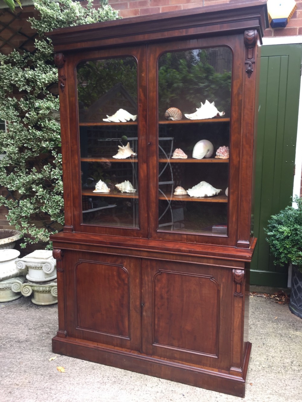 A mid nineteenth-century mahogany library bookcase featuring twin glazed doors over a two-door solid timber cupboard base.