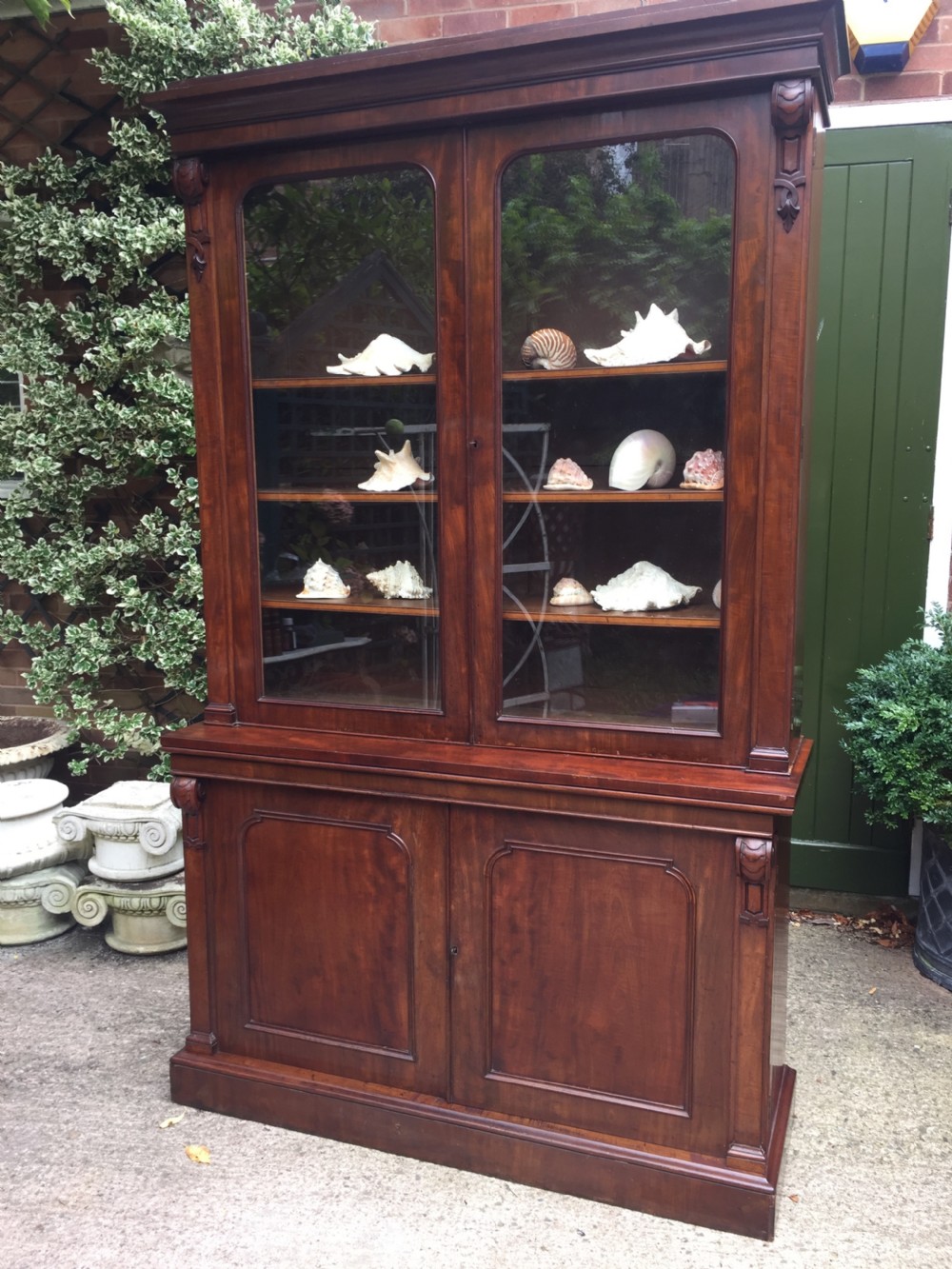 A mid nineteenth-century mahogany library bookcase featuring twin glazed doors over a two-door solid timber cupboard base. View III