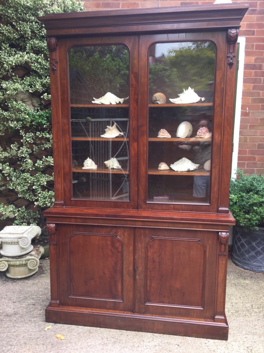 A mid nineteenth-century mahogany library bookcase featuring twin glazed doors over a two-door solid timber cupboard base. View V