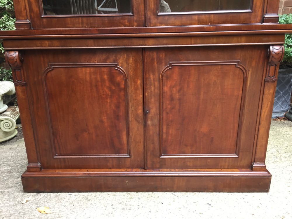A mid nineteenth-century mahogany library bookcase featuring twin glazed doors over a two-door solid timber cupboard base. View VI
