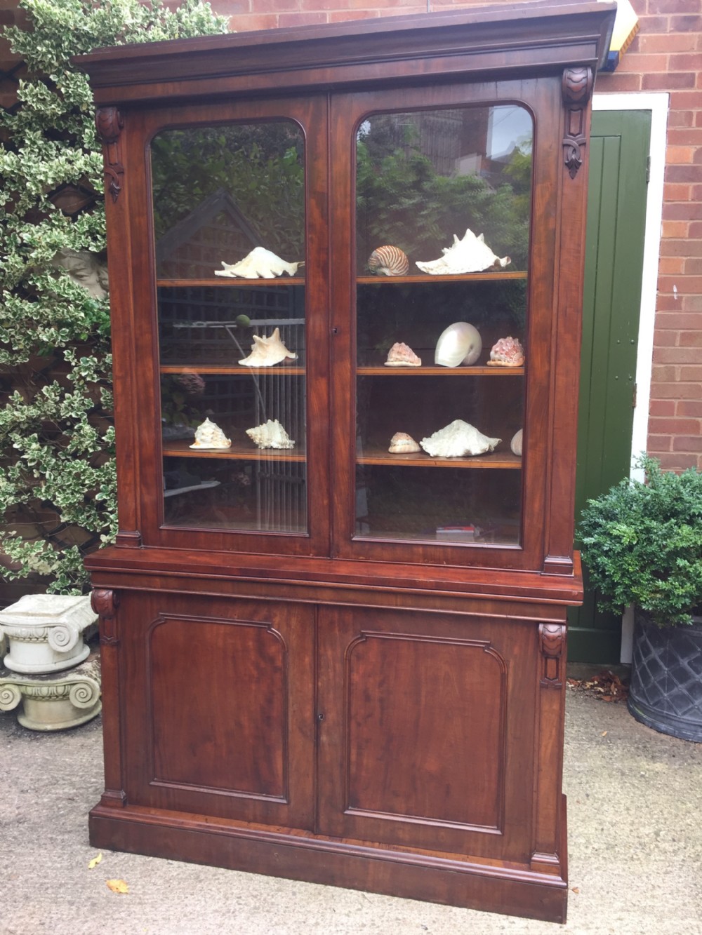 A mid nineteenth-century mahogany library bookcase featuring twin glazed doors over a two-door solid timber cupboard base. View XI