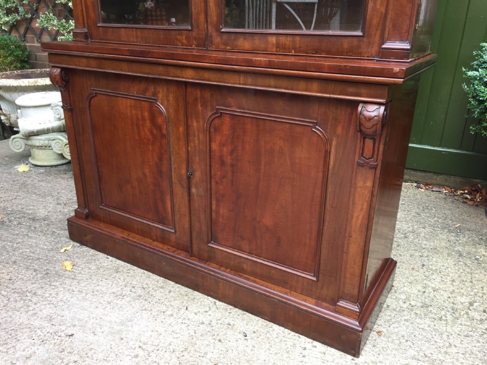 A mid nineteenth-century mahogany library bookcase featuring twin glazed doors over a two-door solid timber cupboard base. View XIII
