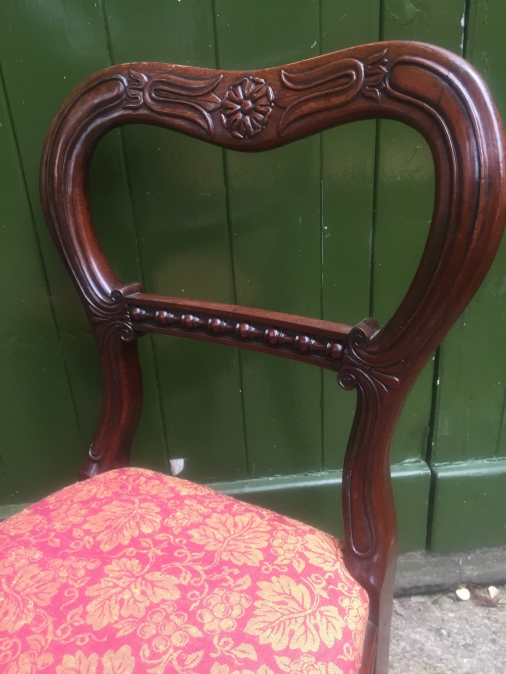 A set of six early nineteenth-century George IV mahogany dining chairs featuring carved balloon back frames, reeded legs, and red pattern upholstered seats. View XII