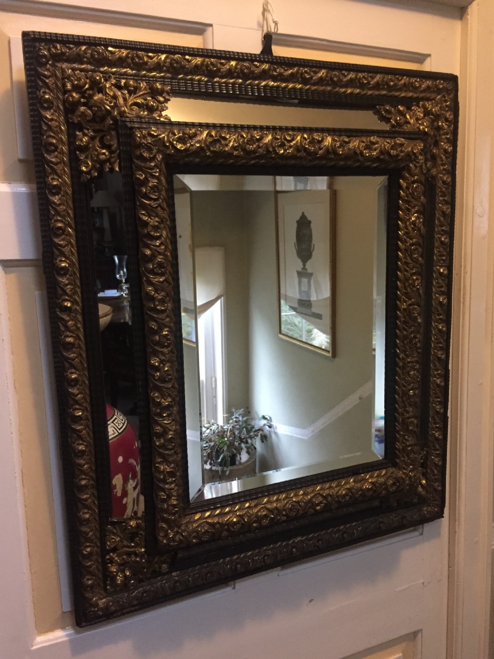 C19th Flemish ebony and repousse brass 'cushion' mirror of C17th design.