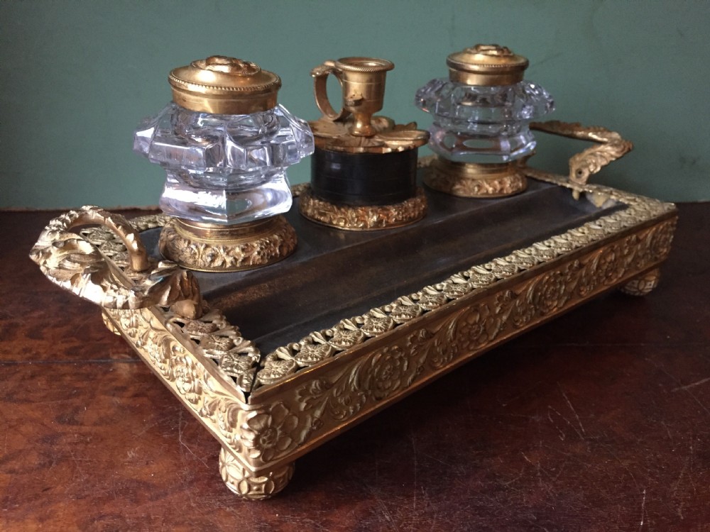 An early nineteenth-century French Empire style ormolu inkstand featuring two cut-crystal inkwells, a central holder, foliate handles, and a decorative gilt bronze tray. View II