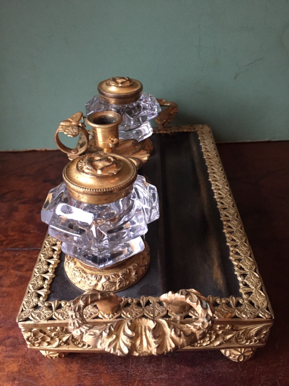 An early nineteenth-century French Empire style ormolu inkstand featuring two cut-crystal inkwells, a central holder, foliate handles, and a decorative gilt bronze tray. View III