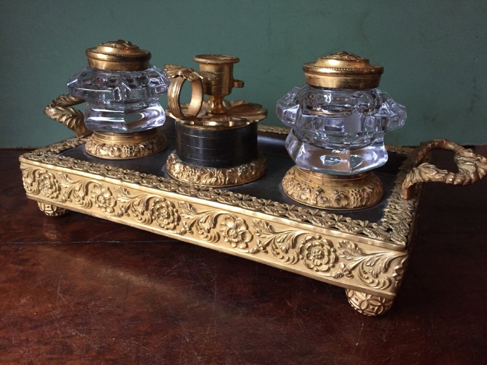 An early nineteenth-century French Empire style ormolu inkstand featuring two cut-crystal inkwells, a central holder, foliate handles, and a decorative gilt bronze tray. View IV