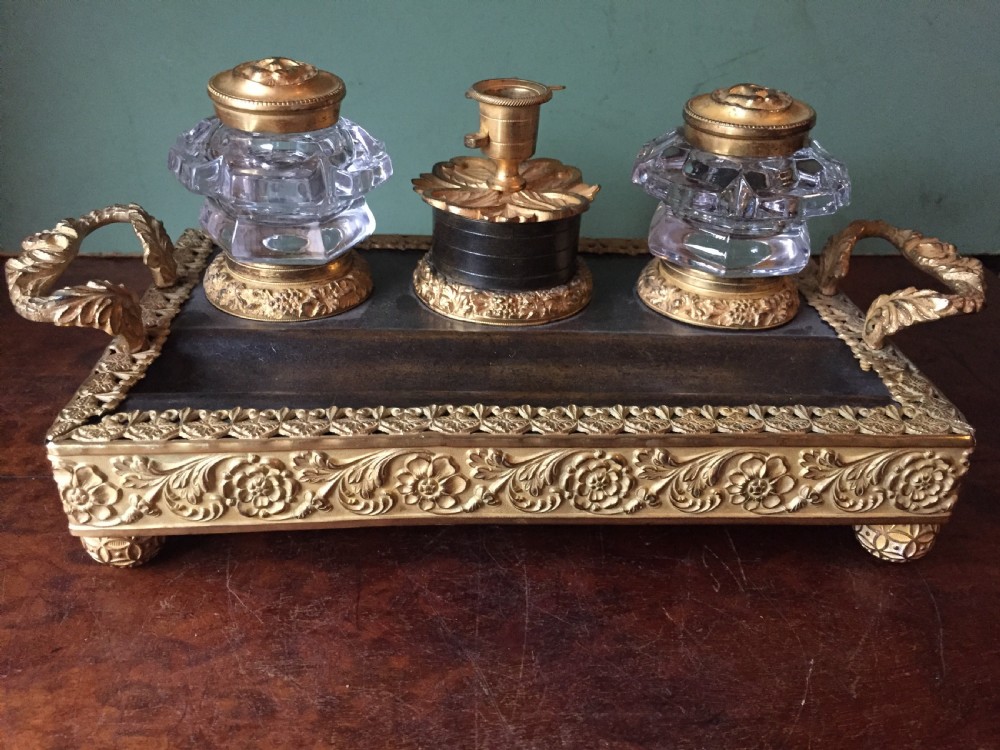 An early nineteenth-century French Empire style ormolu inkstand featuring two cut-crystal inkwells, a central holder, foliate handles, and a decorative gilt bronze tray. View XIV
