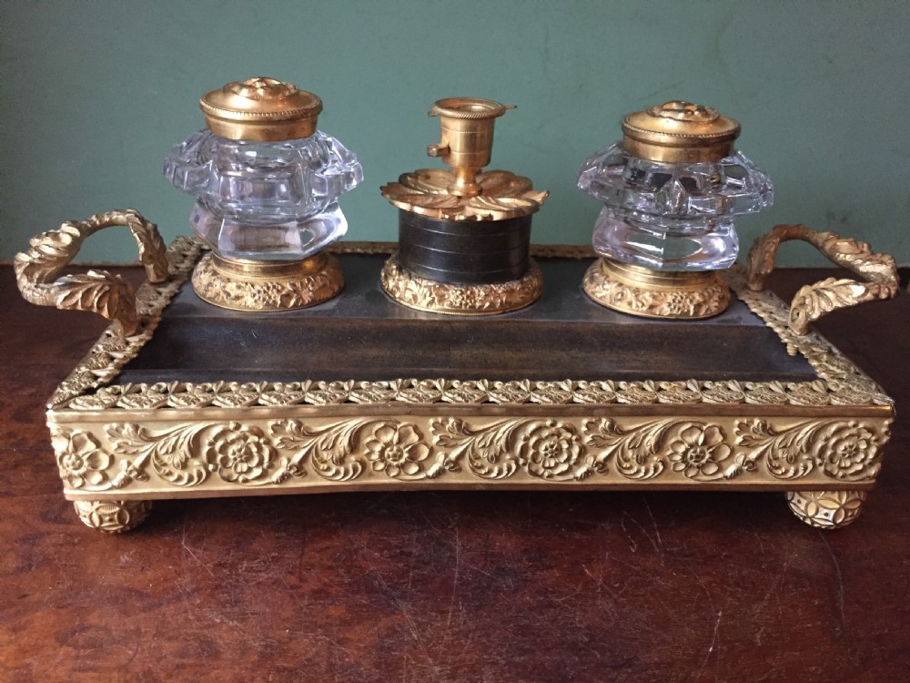 An early nineteenth-century French Empire style ormolu inkstand featuring two cut-crystal inkwells, a central holder, foliate handles, and a decorative gilt bronze tray. View XV