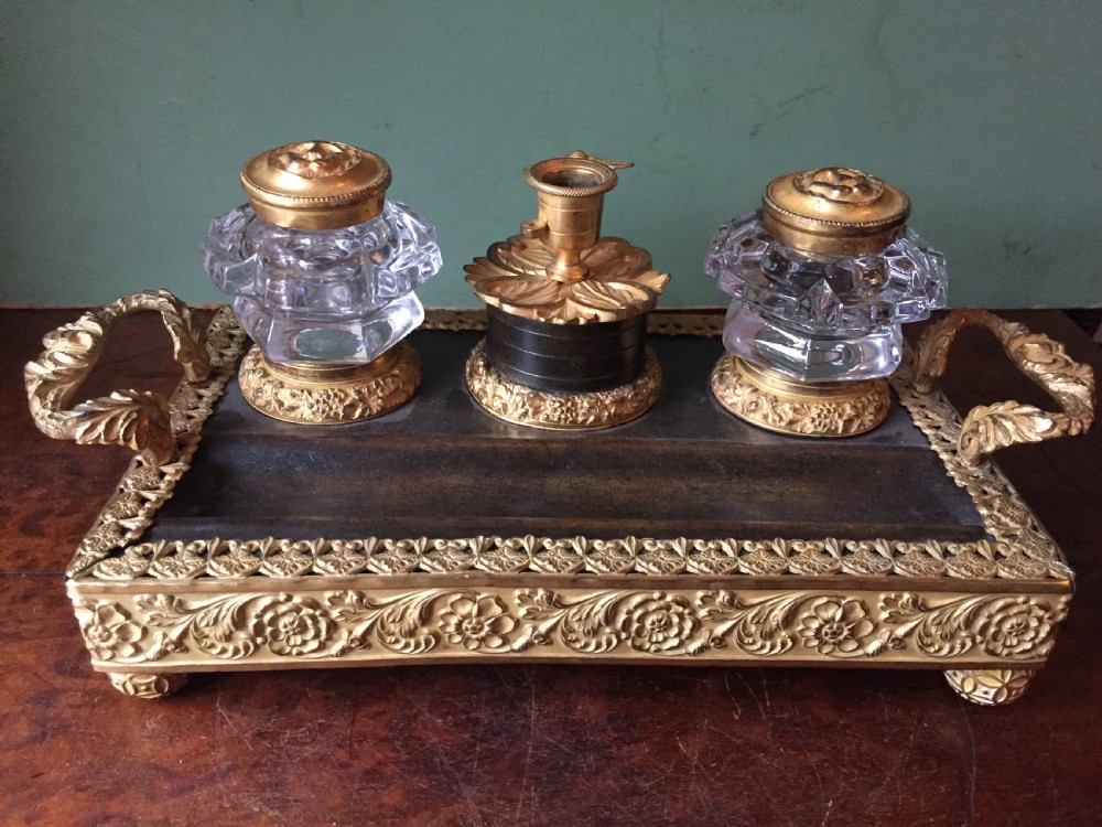 An early nineteenth-century French Empire style ormolu inkstand featuring two cut-crystal inkwells, a central holder, foliate handles, and a decorative gilt bronze tray. View XVI