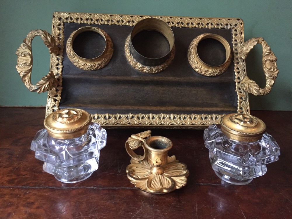 An early nineteenth-century French Empire style ormolu inkstand featuring two cut-crystal inkwells, a central holder, foliate handles, and a decorative gilt bronze tray. View XVII