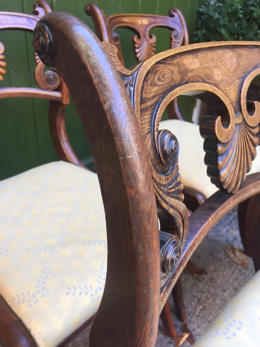 A set of four early nineteenth-century Regency Greek Revival side chairs with carved anthemion backrests and yellow upholstered seats. View V
