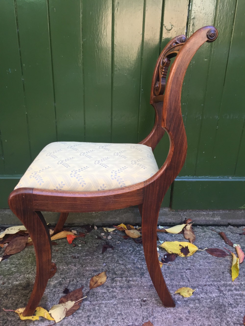 A set of four early nineteenth-century Regency Greek Revival side chairs with carved anthemion backrests and yellow upholstered seats. View X
