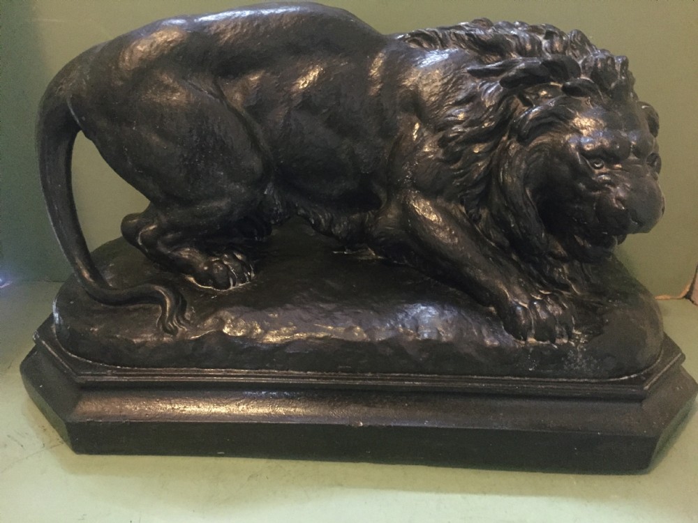 A nineteenth-century bronzed plaster sculpture depicting a prowling lion mounted on an octagonal base. View II
